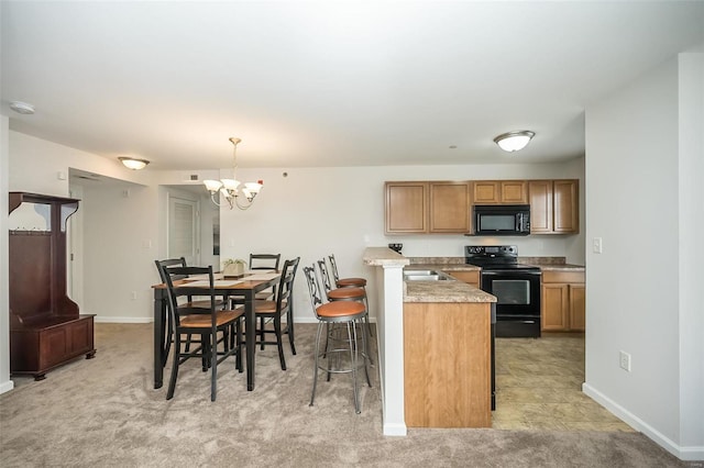 kitchen with light stone countertops, hanging light fixtures, a kitchen breakfast bar, a notable chandelier, and black appliances