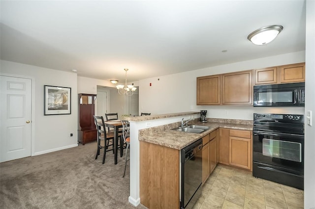 kitchen with black appliances, pendant lighting, kitchen peninsula, and sink