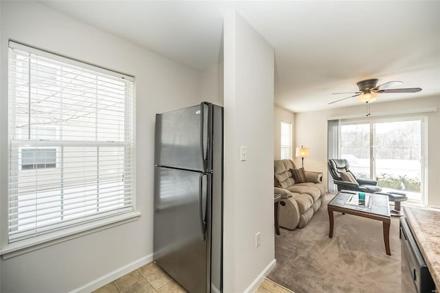 kitchen with ceiling fan, black fridge, and light tile patterned floors