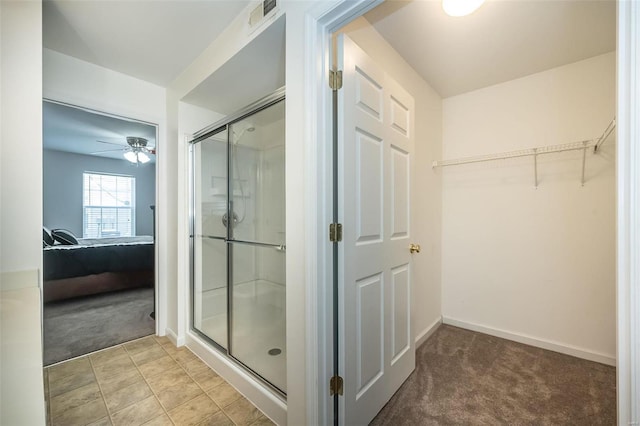 bathroom with a shower with door and ceiling fan