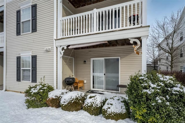 snow covered property featuring a balcony