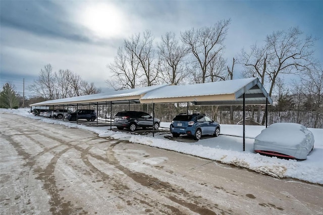 snow covered parking featuring a carport