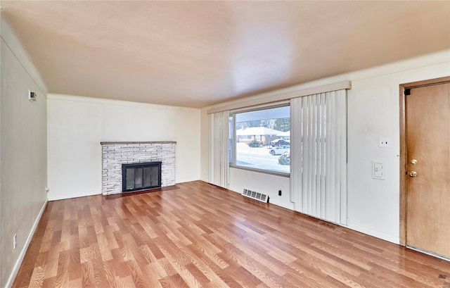 unfurnished living room featuring a fireplace and light hardwood / wood-style floors