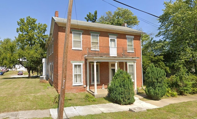 view of front facade with a front yard and a balcony