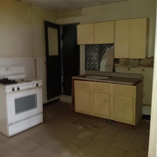 kitchen featuring white gas stove and light tile patterned flooring