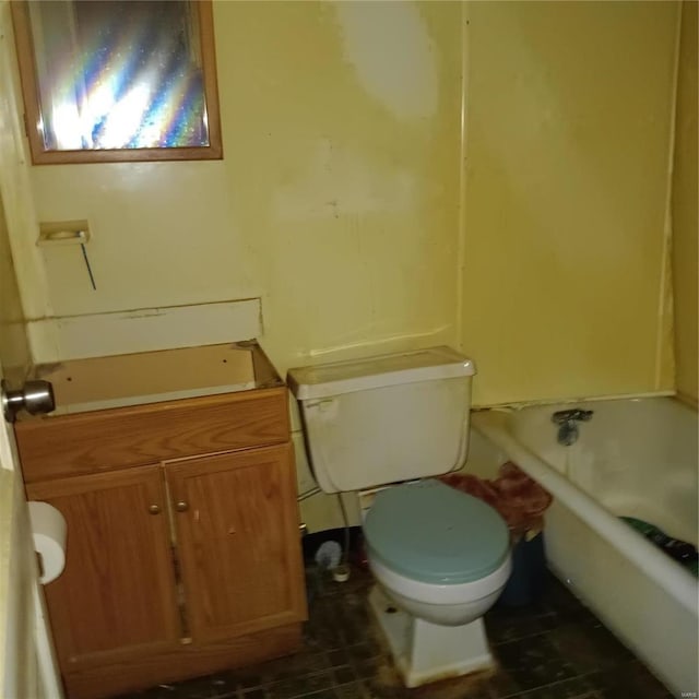 bathroom featuring toilet, vanity, and a washtub