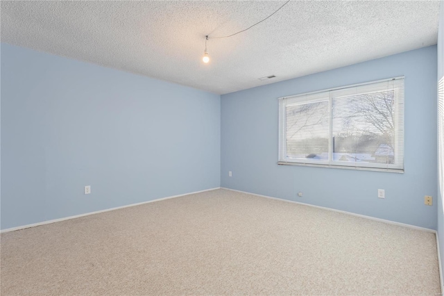 carpeted empty room featuring a textured ceiling