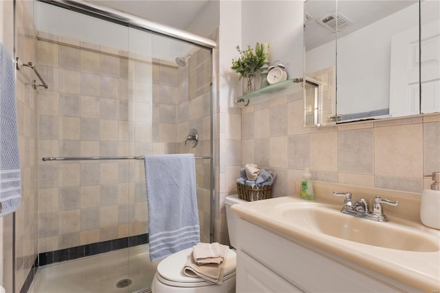 bathroom with toilet, tasteful backsplash, tile walls, walk in shower, and vanity