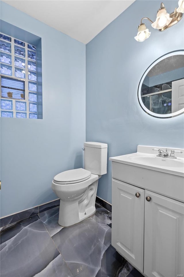 bathroom with vanity, a notable chandelier, and toilet