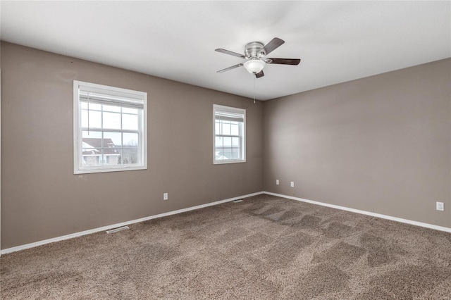 empty room with carpet flooring, ceiling fan, and a healthy amount of sunlight