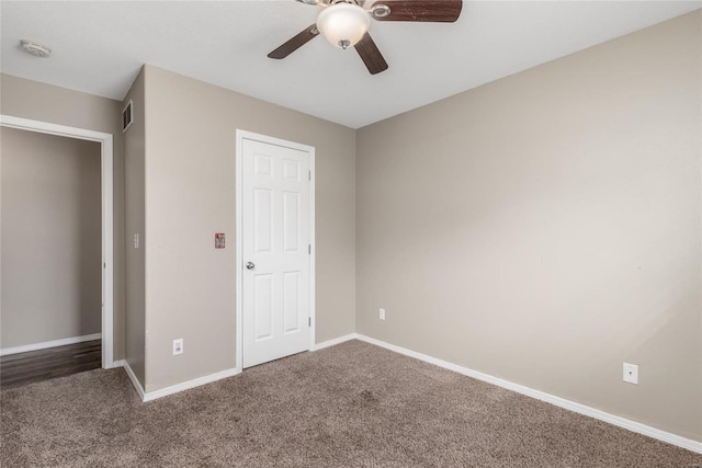 unfurnished bedroom with dark carpet and ceiling fan