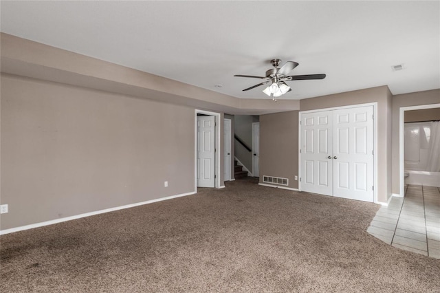 unfurnished bedroom featuring connected bathroom, ceiling fan, and carpet floors