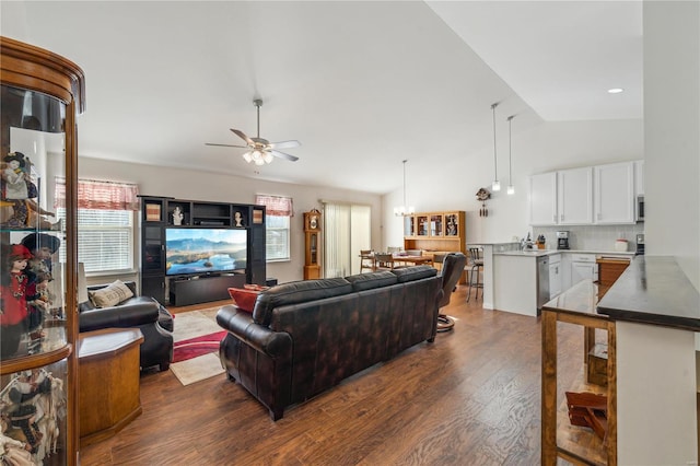 living room with vaulted ceiling, sink, dark hardwood / wood-style floors, and ceiling fan with notable chandelier