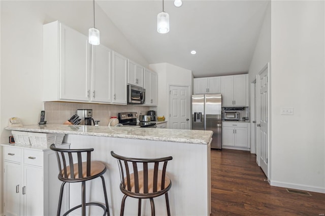 kitchen featuring decorative backsplash, stainless steel appliances, kitchen peninsula, and white cabinets