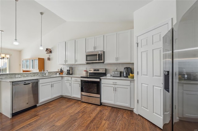 kitchen featuring white cabinets, stainless steel appliances, decorative light fixtures, and backsplash