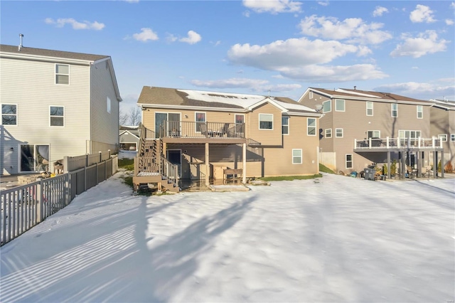 snow covered house with a wooden deck