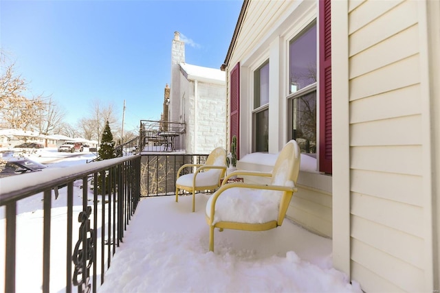 view of snow covered back of property