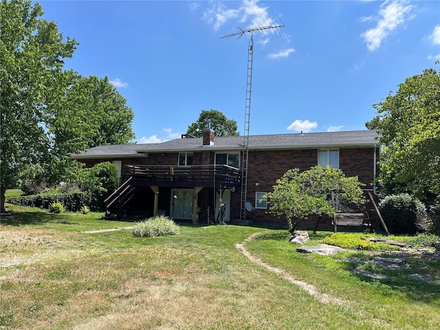 rear view of property featuring a lawn and a wooden deck