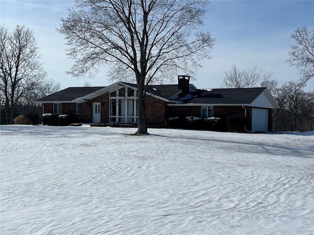 snow covered property with a garage