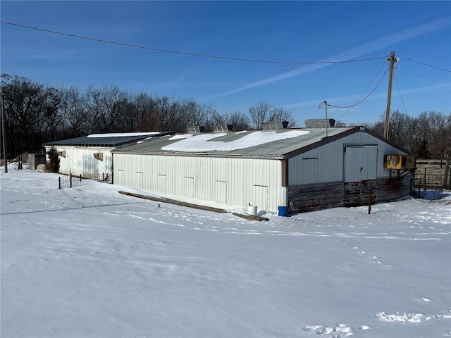 view of snowy exterior with an outbuilding