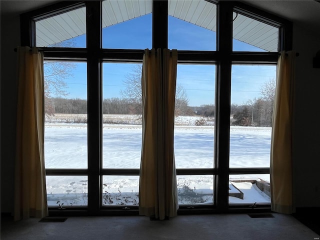 doorway to outside featuring dark colored carpet and vaulted ceiling