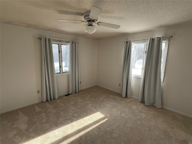 empty room featuring light carpet, a textured ceiling, and ceiling fan