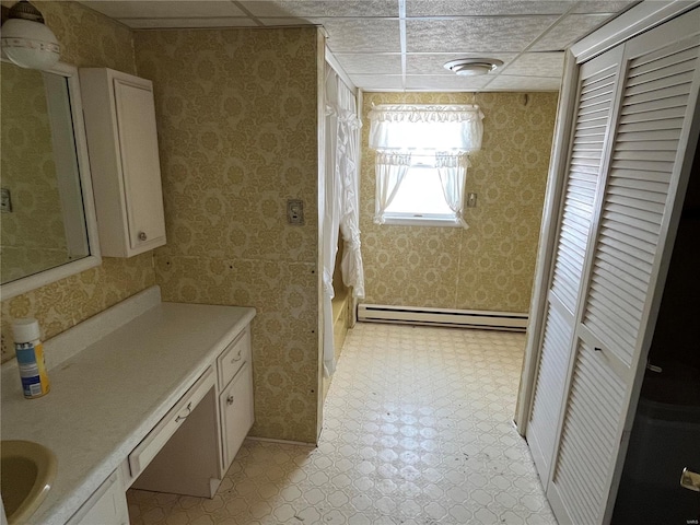 bathroom with a paneled ceiling and a baseboard radiator