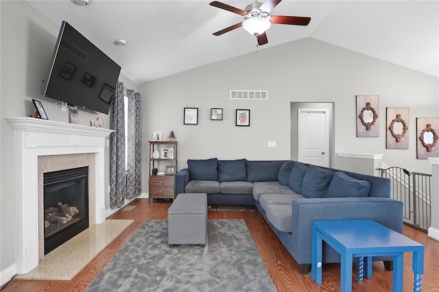 living room with ceiling fan, dark hardwood / wood-style floors, and vaulted ceiling