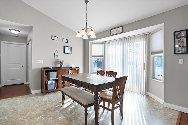 dining area with a chandelier and vaulted ceiling