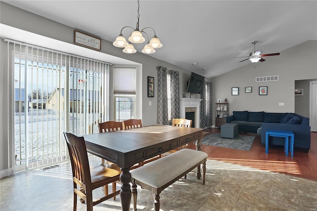 dining area featuring lofted ceiling and ceiling fan with notable chandelier