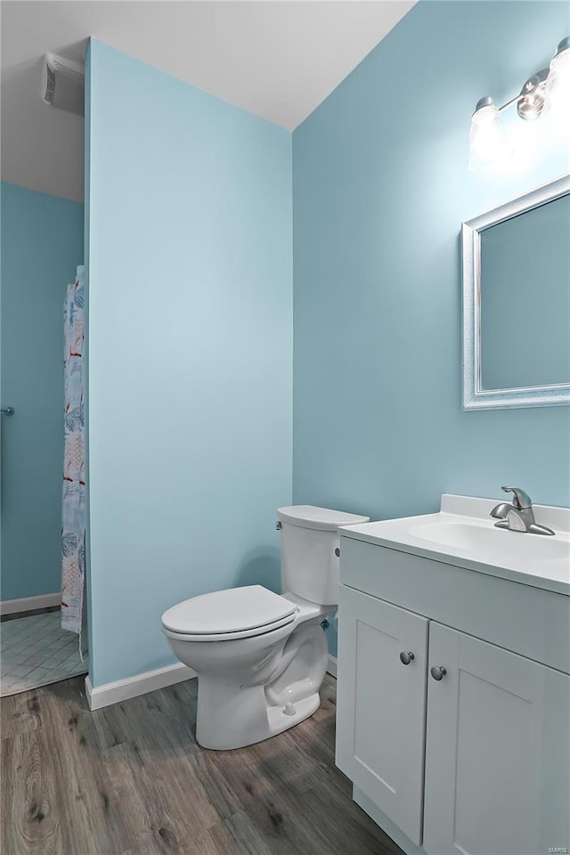 bathroom with hardwood / wood-style flooring, vanity, and toilet