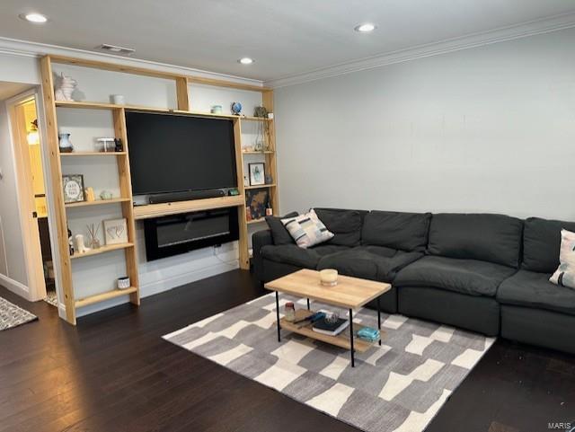 living room with dark hardwood / wood-style flooring and crown molding