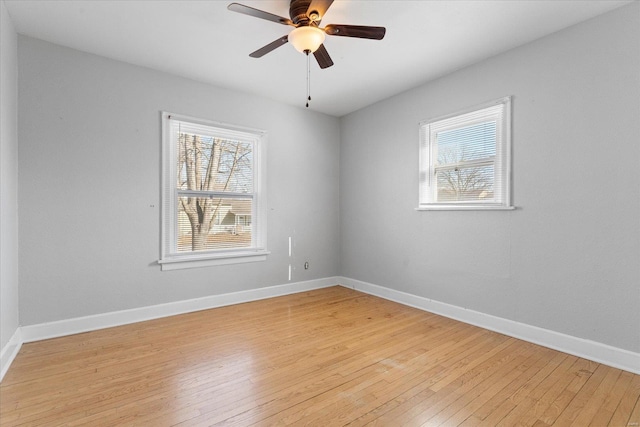 empty room with ceiling fan and light hardwood / wood-style flooring