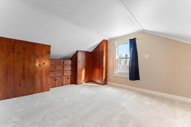 bonus room featuring lofted ceiling and light colored carpet