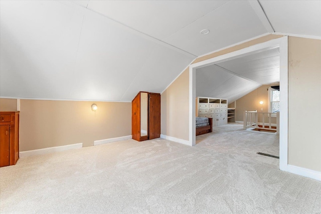 bonus room featuring lofted ceiling and light colored carpet