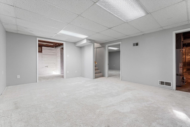 basement featuring carpet floors and a paneled ceiling