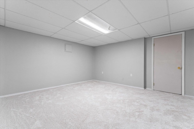 basement featuring a drop ceiling and carpet