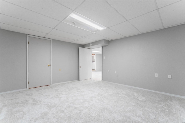 basement with a paneled ceiling and carpet