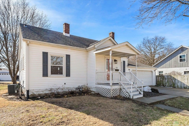 bungalow with a garage, a front yard, central AC, and covered porch