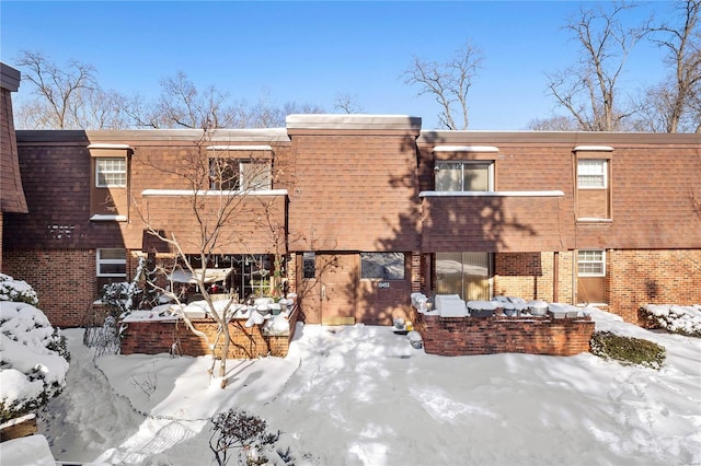 view of snow covered rear of property