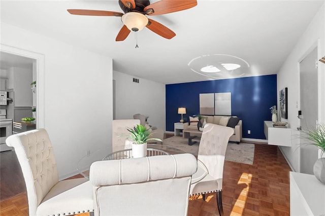 dining space featuring ceiling fan and parquet flooring