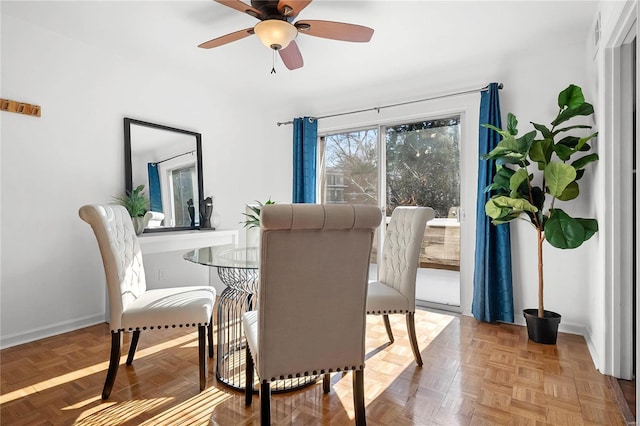 dining space with parquet flooring and ceiling fan