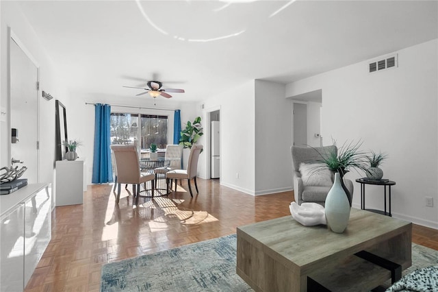 living room with ceiling fan and parquet floors