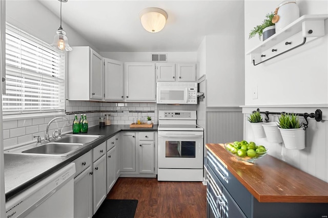 kitchen featuring sink, dark wood-type flooring, decorative light fixtures, white appliances, and white cabinets