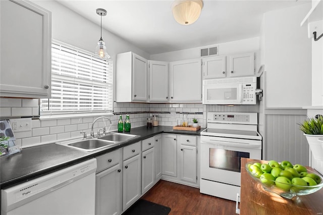 kitchen with pendant lighting, white appliances, sink, dark hardwood / wood-style floors, and white cabinetry