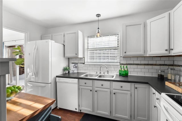 kitchen featuring sink, tasteful backsplash, pendant lighting, white appliances, and white cabinets