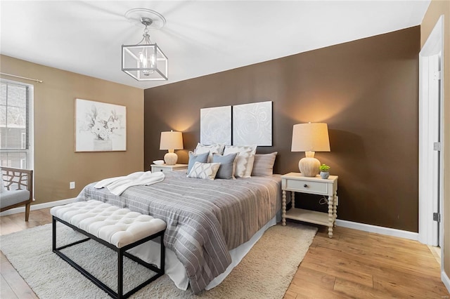 bedroom featuring light wood-type flooring and an inviting chandelier