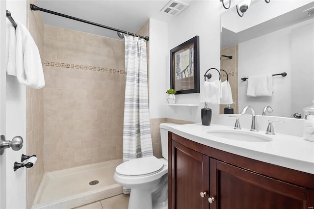 bathroom with tile patterned floors, vanity, toilet, and curtained shower