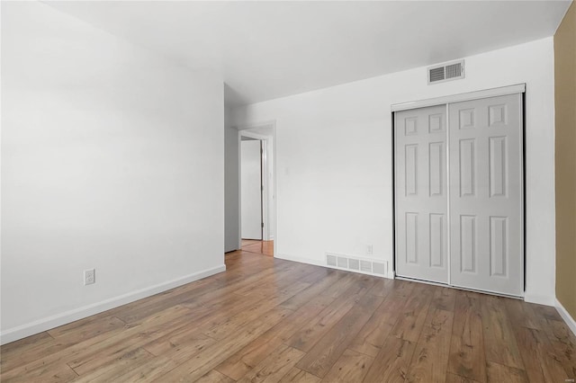 unfurnished bedroom featuring light hardwood / wood-style flooring and a closet