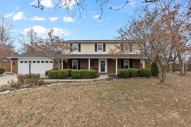 front of property featuring a porch, a front yard, and a garage